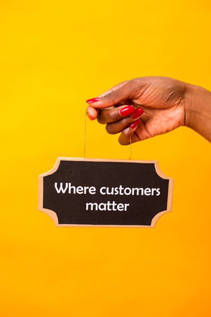 Hand holding a sign with 'Where customers matter' on a vibrant yellow backdrop.